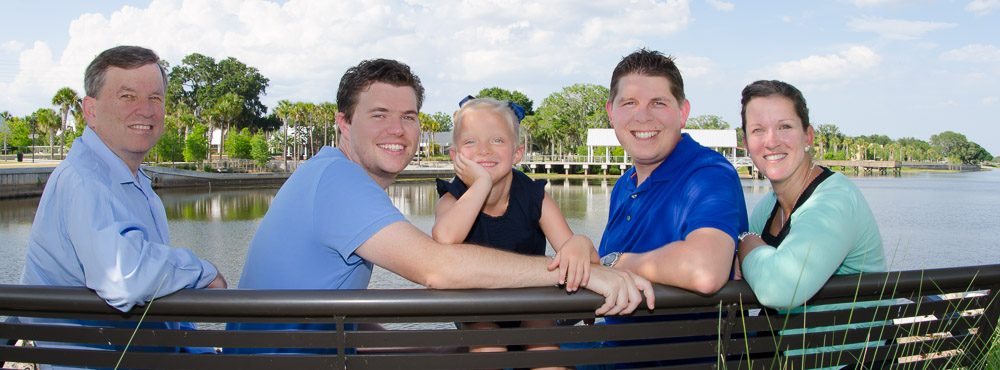a group of people sitting on a bench posing for the camera