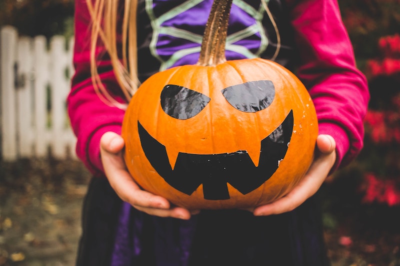 Girl holding pumpkin on Halloween